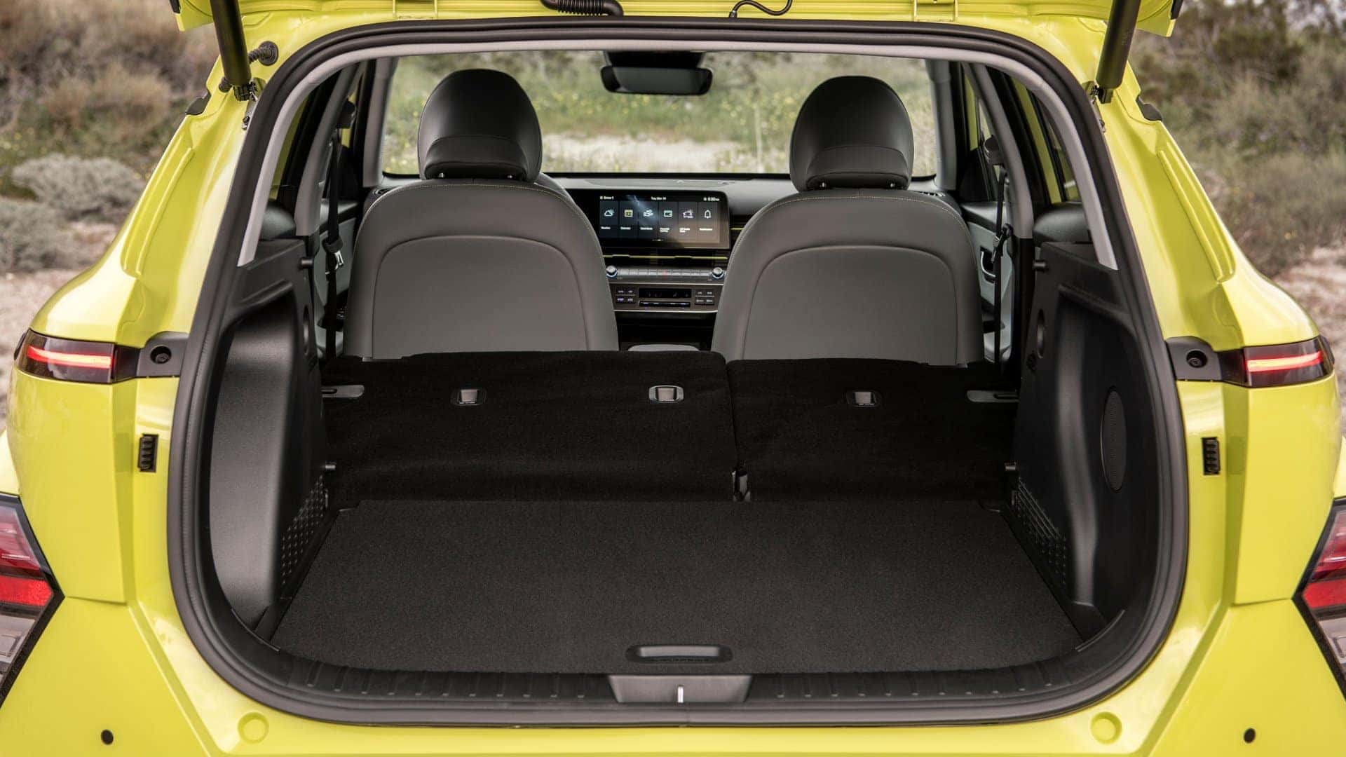 2025 Hyundai Kona Electric cargo area with rear seats folded down showing spacious trunk storage.