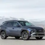 2026 Hyundai Tucson SUV parked in front three quarter view with blue exterior and modern grille design.