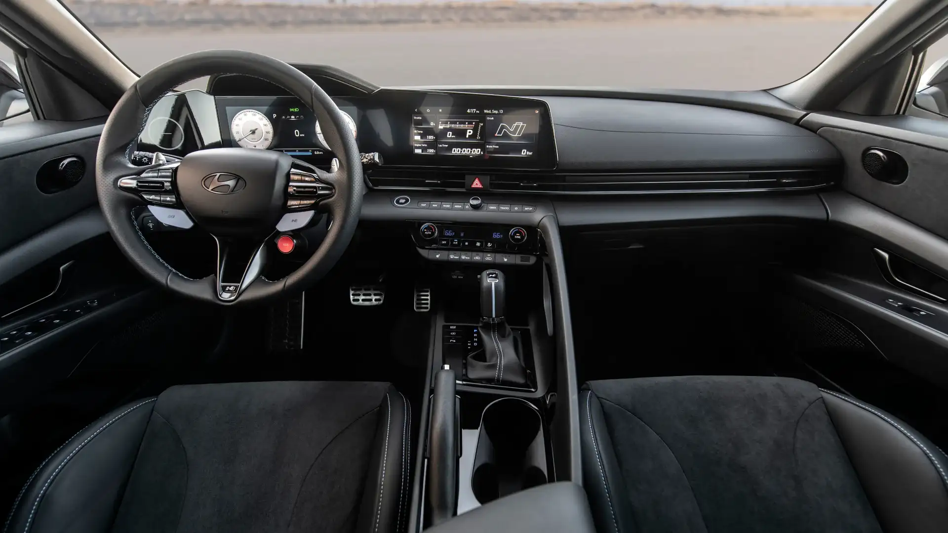 Interior front cabin view of 2026 Hyundai Elantra N showing steering wheel, digital dashboard, and center console.