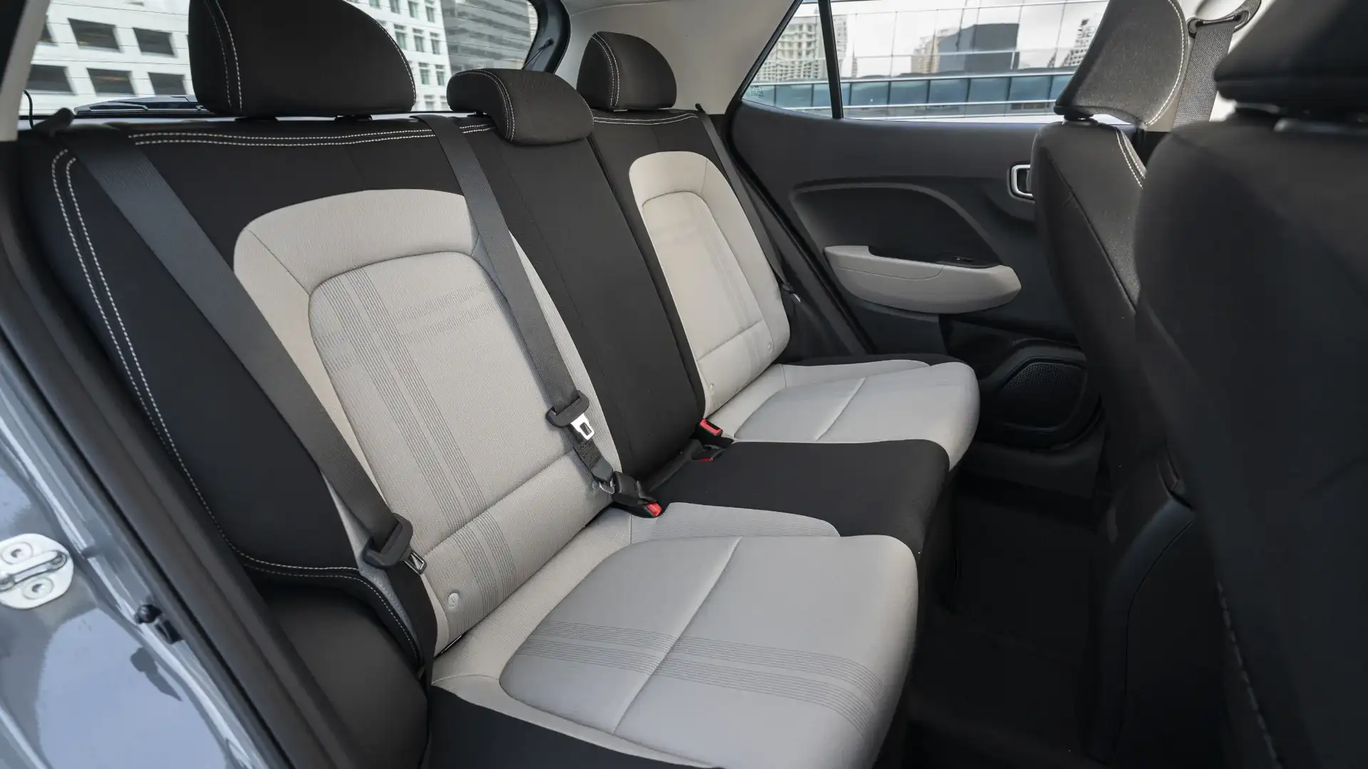 2026 Hyundai Venue rear interior view showing back seats, headrests, and door panels.