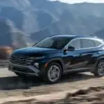 2026 Hyundai Tucson Hybrid black SUV driving through mountain road with motion blur background.