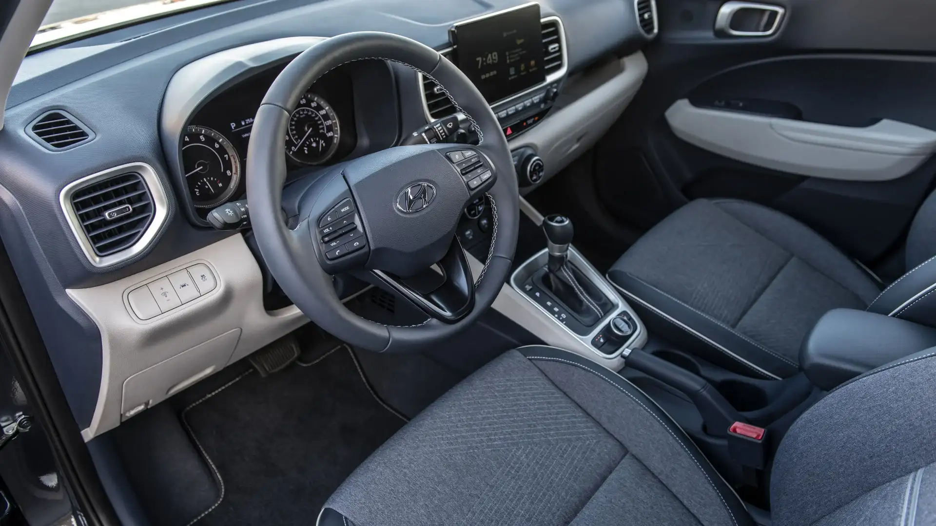 2026 Hyundai Venue gray cloth interior with steering wheel, dashboard screen, and center console.