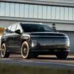 2027 Hyundai IONIQ 9 black electric SUV shown from front angle near modern building with LED lights.