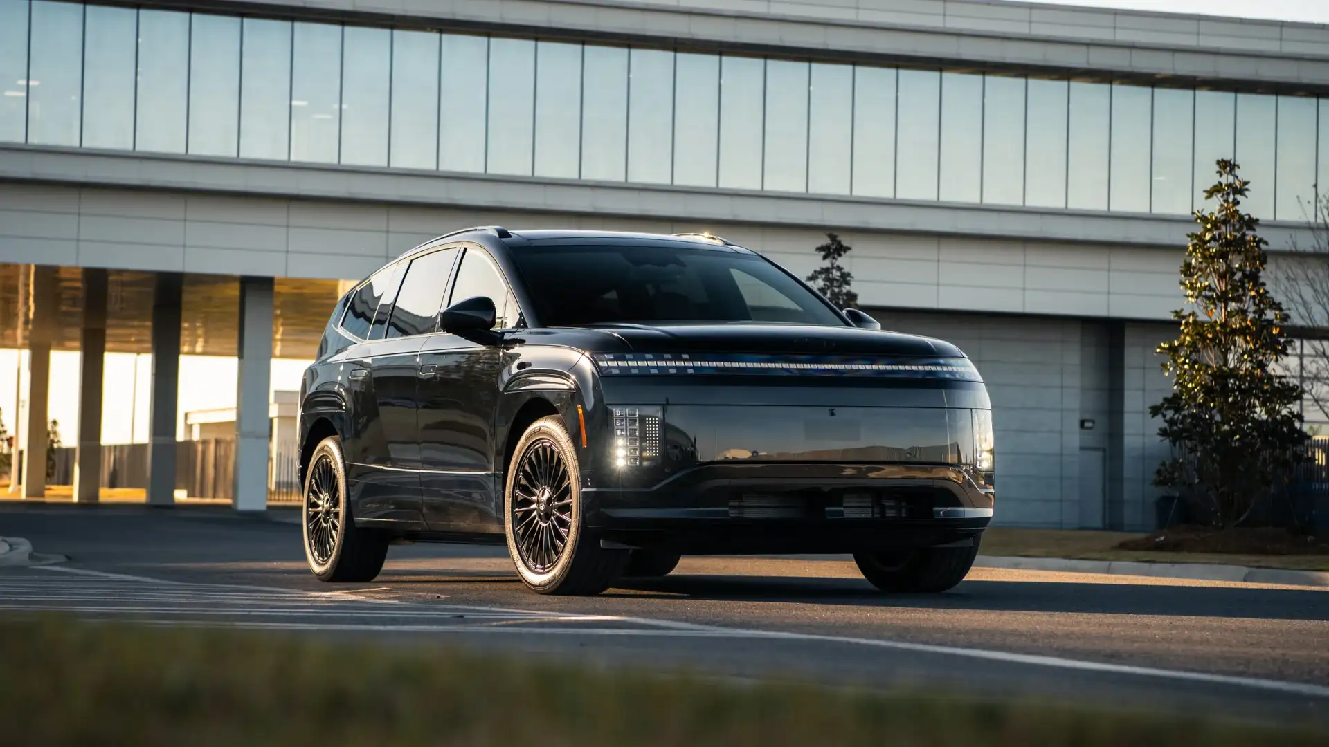 2027 Hyundai IONIQ 9 black electric SUV shown from front angle near modern building with LED lights.