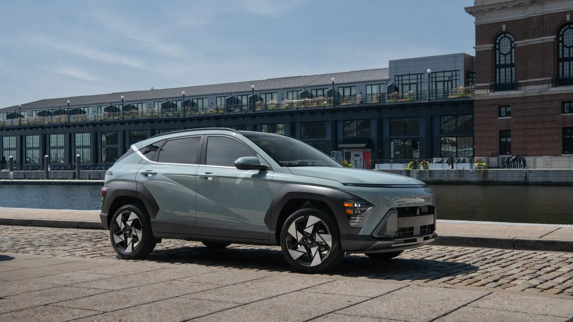 2027 Hyundai Kona gray compact SUV parked by waterfront with side profile and modern wheel design.