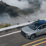 Aerial view of the 2025 Hyundai Tucson Plug-in Hybrid in silver driving along a mountain road.