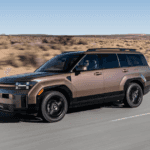 2025 Hyundai Santa Fe in motion on open road with arid landscape backdrop.