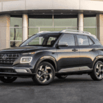 2025 Hyundai Venue compact SUV parked outside modern building with LED lights on.