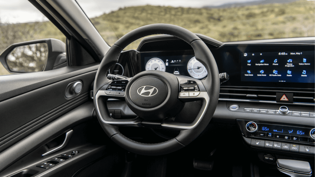 Steering wheel and digital cluster of the 2025 Hyundai Elantra with infotainment interface.