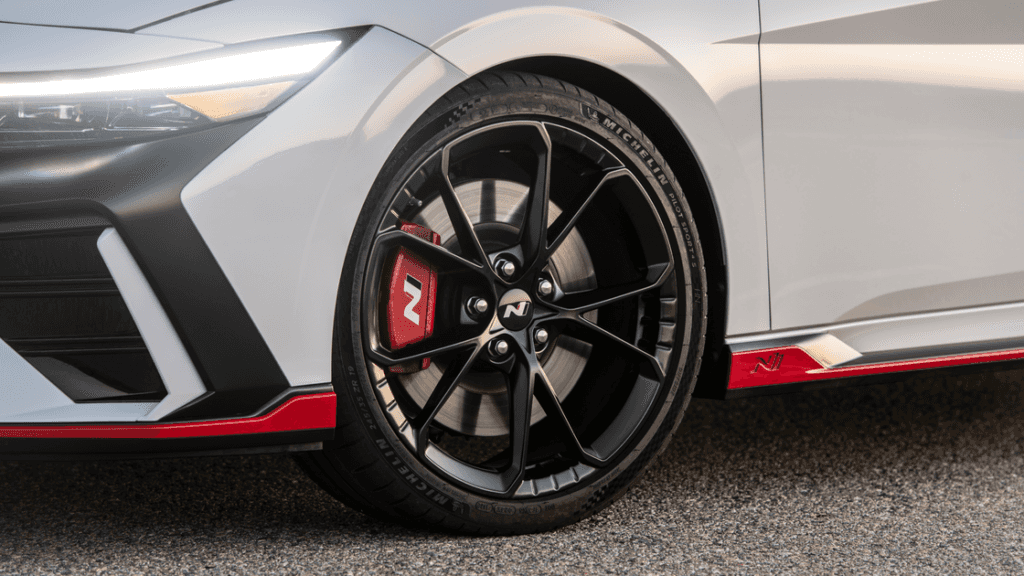 Front wheel of 2025 Hyundai Elantra N featuring red N caliper and black performance rim.