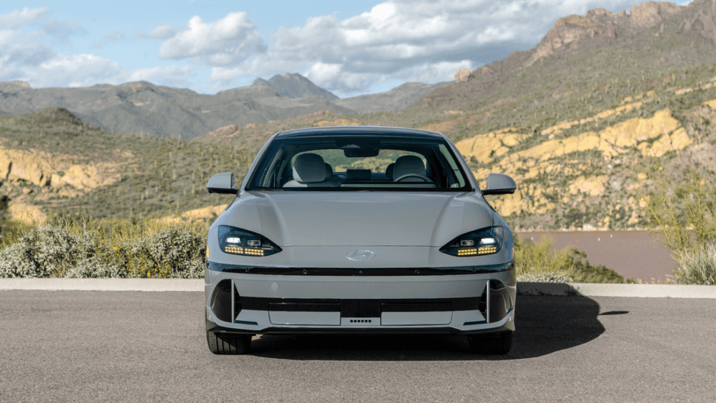 Front view of 2025 Hyundai IONIQ 6 in gray parked with scenic mountain backdrop.