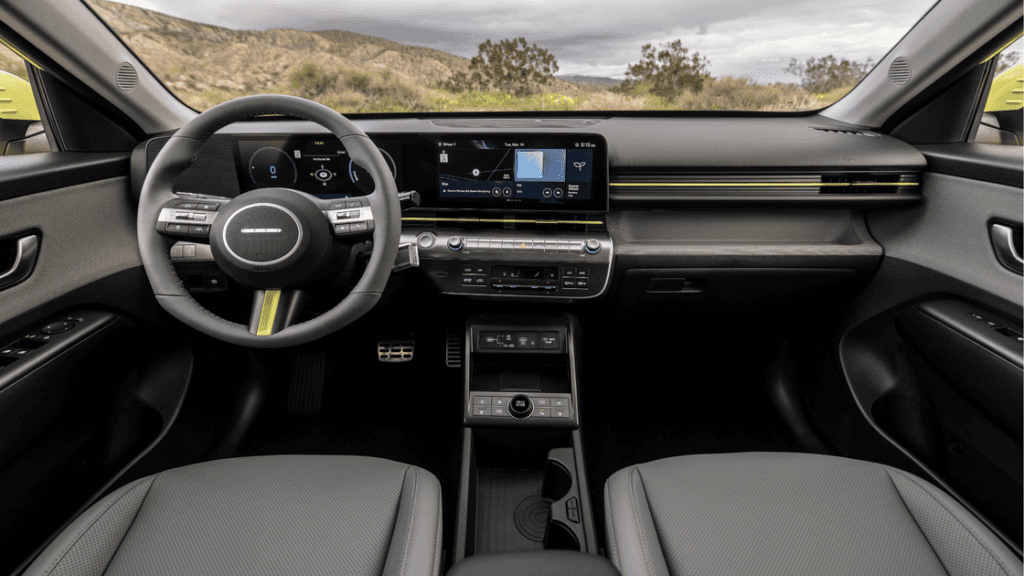 Side profile of the 2025 Hyundai Kona Electric in lime green, parked against a desert mountain backdrop.