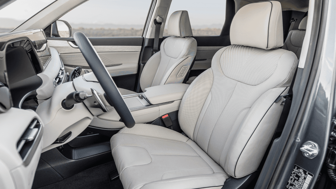 Front seats of 2025 Hyundai Palisade with light leather upholstery and center console.
