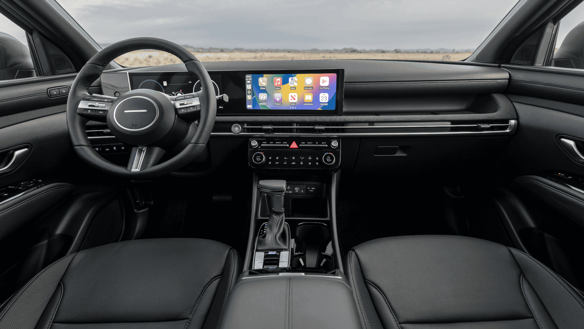 2025 Hyundai Santa Cruz front interior showing black leather seats, touchscreen, and Apple CarPlay