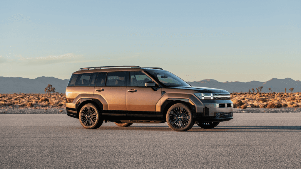 Side profile of the 2025 Hyundai Santa Fe Hybrid in bronze finish parked in a desert landscape.