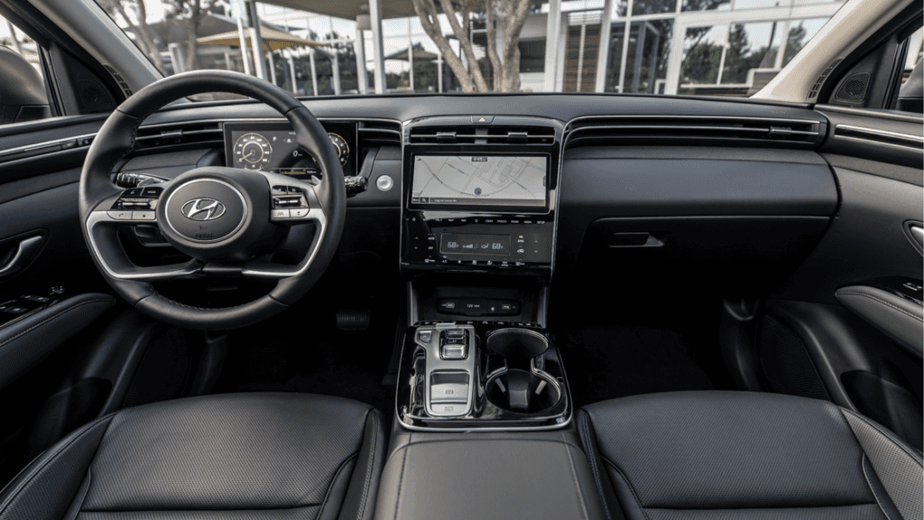 Driver’s view of 2025 Hyundai Tucson Hybrid interior featuring digital cluster and touchscreen.