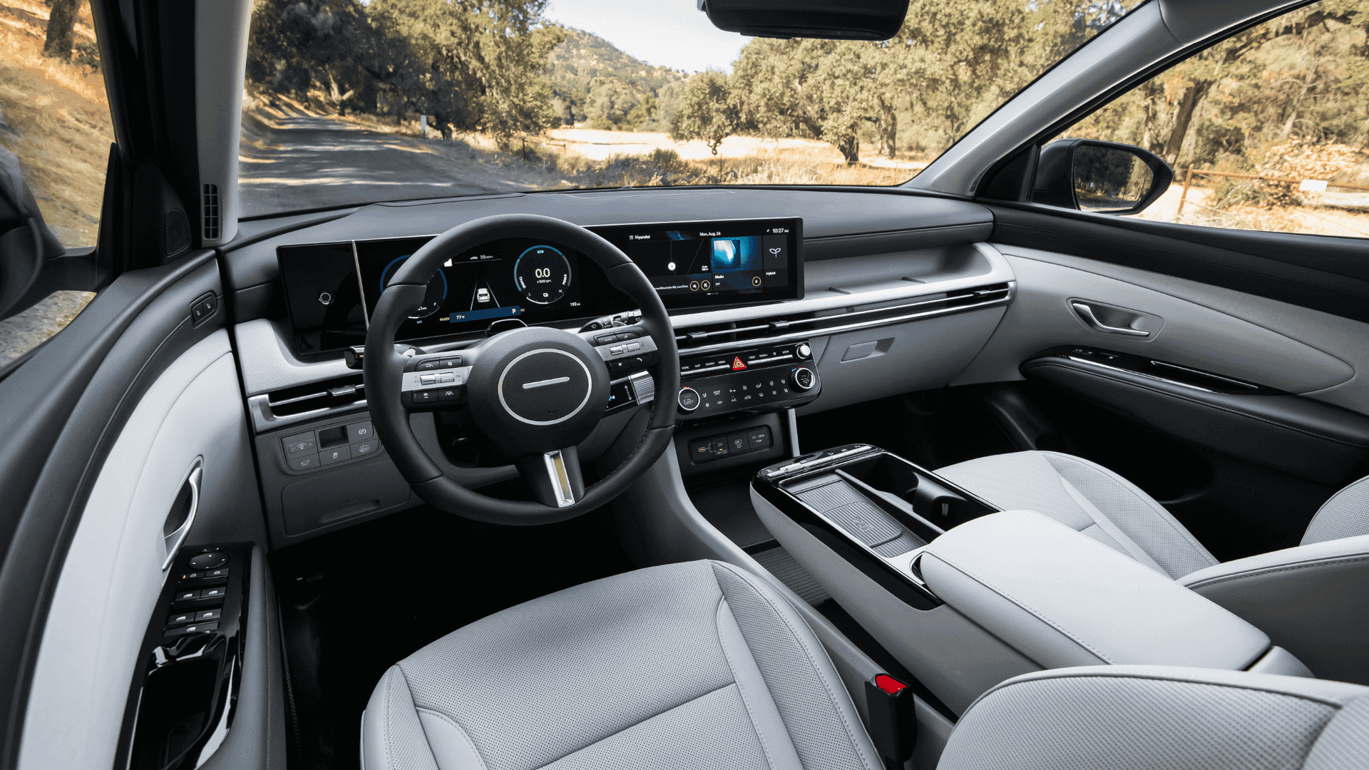 2025 Hyundai Tucson Hybrid cockpit with panoramic dash display and leather-wrapped steering wheel
