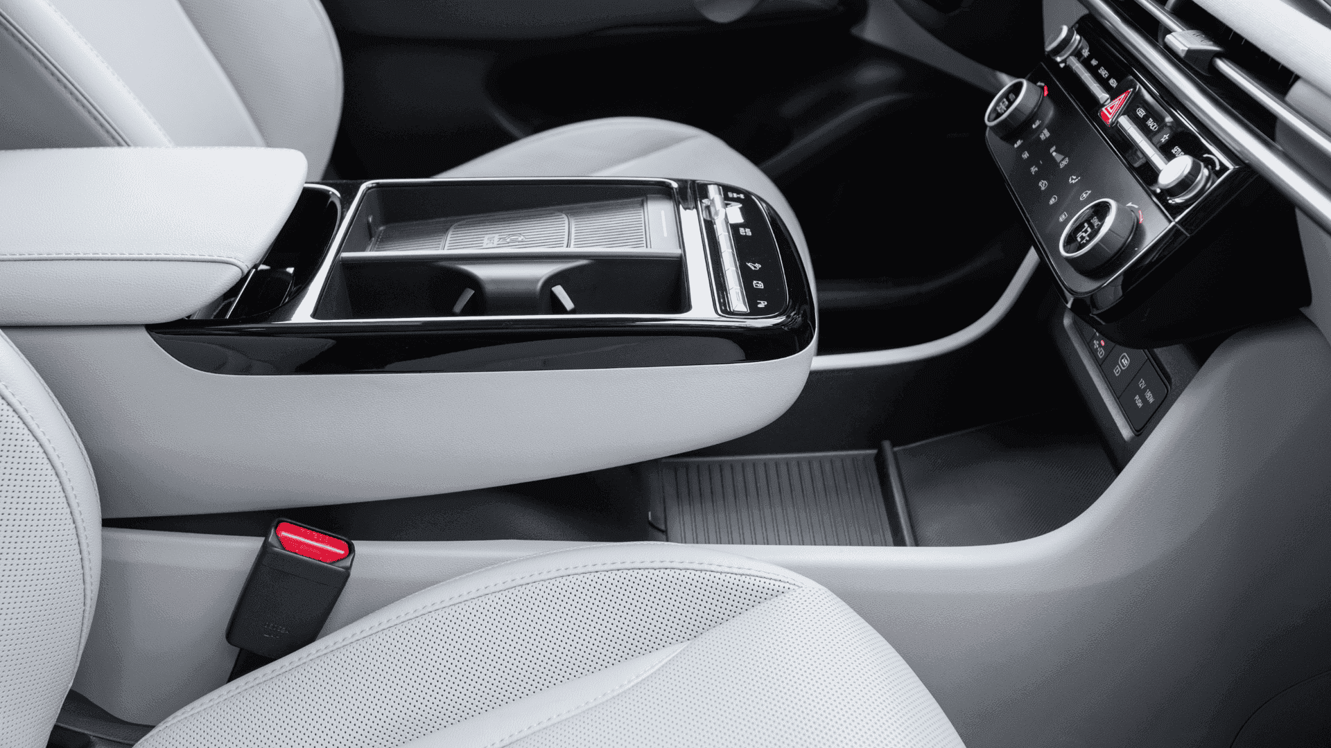Close-up of 2025 Tucson Hybrid center armrest, cup holders, and climate control panel