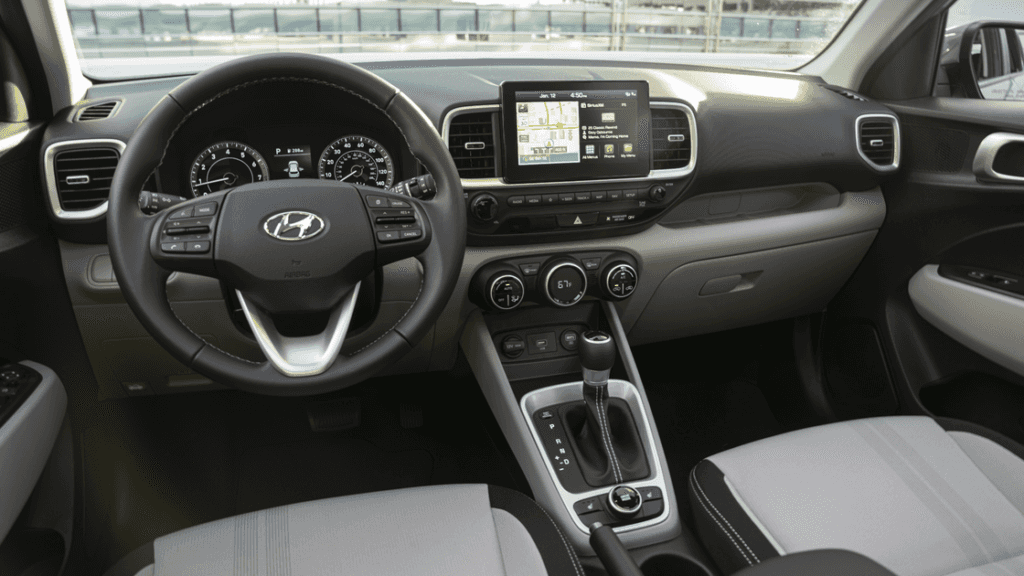 Front interior view of 2025 Hyundai Venue with touchscreen display and steering wheel.