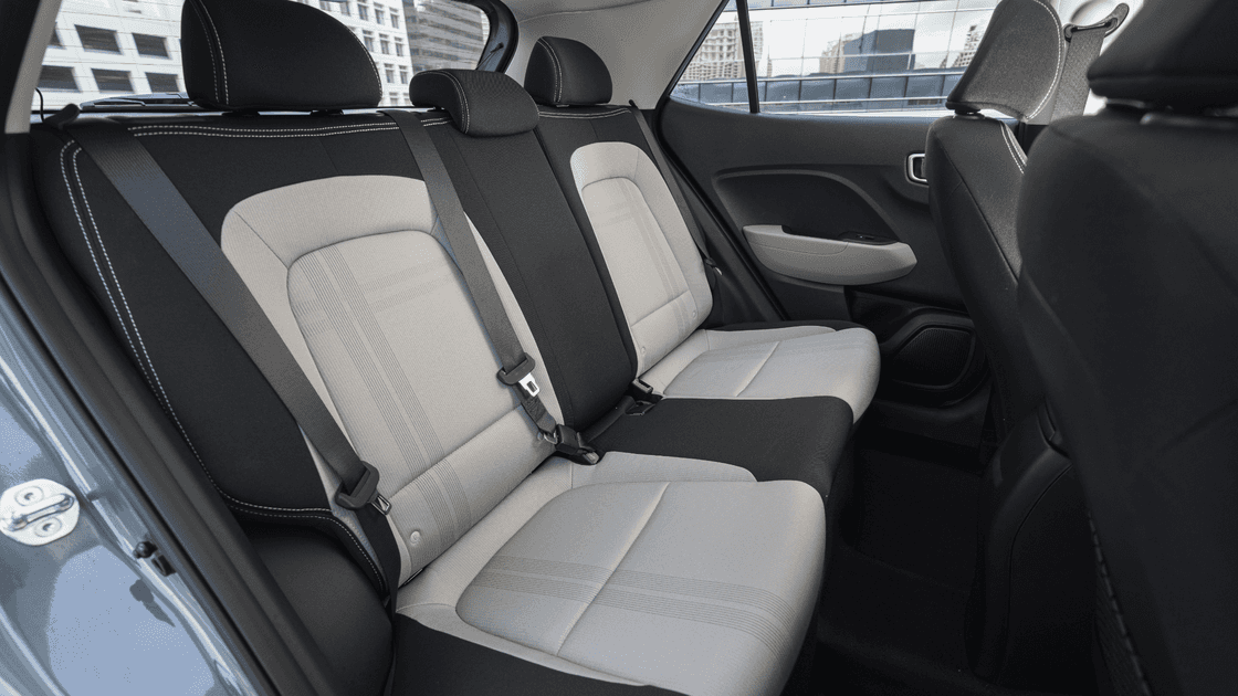 Rear seats of the 2025 Hyundai Venue shown in two-tone upholstery with seatbelt details.