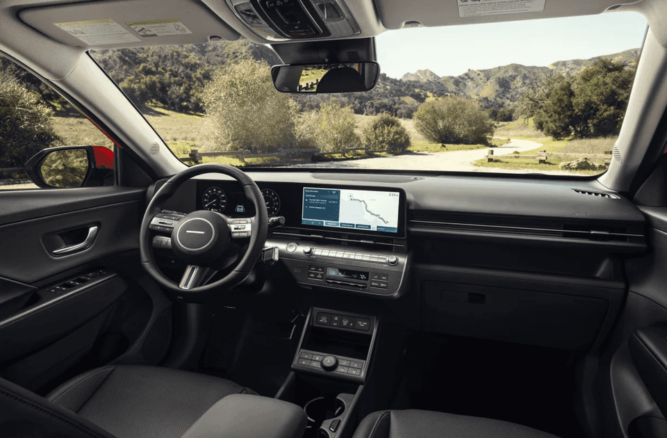 Interior view of 2025 Hyundai Kona showing dashboard, touchscreen display, and steering wheel.