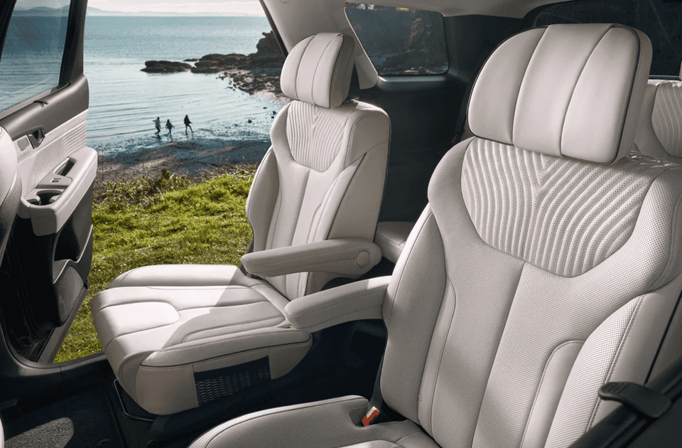 Second-row captain’s chairs in the 2025 Hyundai Palisade with light leather upholstery and ocean backdrop.
