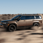 2025 Hyundai Santa Fe Hybrid driving off-road in desert terrain with bold exterior and rugged stance.