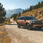 2025 Hyundai Santa Fe Hybrid in matte bronze driving on a rugged mountain road with scenic views.
