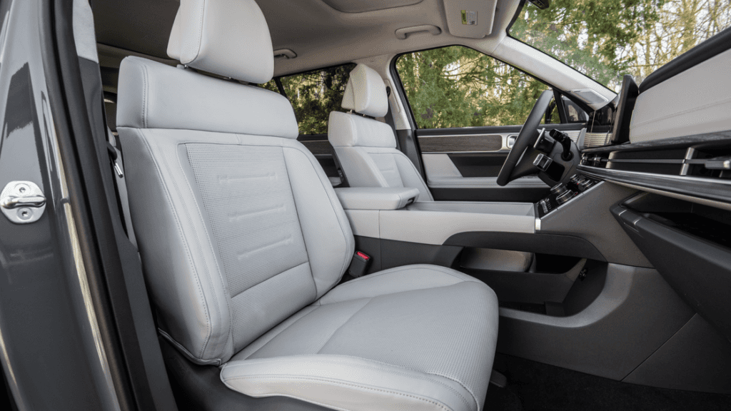 Front-seat view of the 2025 Hyundai Santa Fe interior featuring light leather upholstery and modern trim.