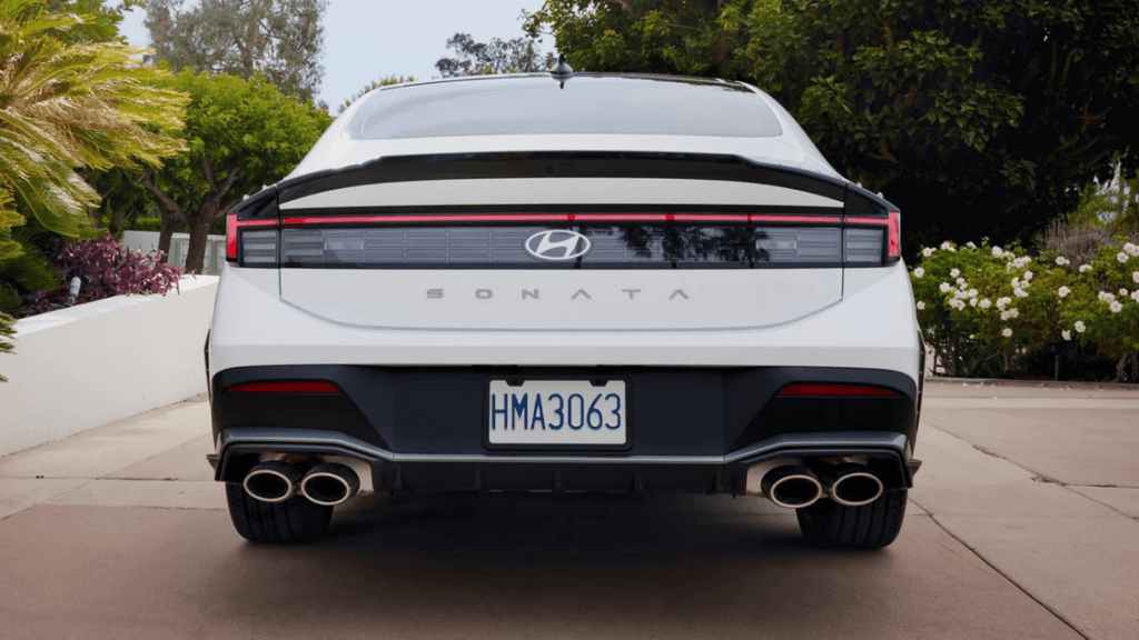 Rear view of a 2025 Hyundai Sonata in white showcasing its LED taillight bar and quad exhaust tips.