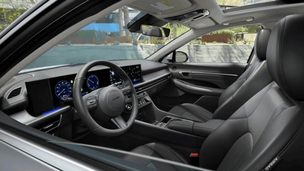 Interior view of the 2025 Hyundai Sonata showing the driver cockpit, digital display, and black leather seats.