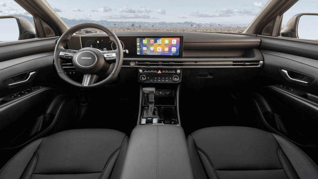 2025 Hyundai Tucson interior cabin view with panoramic touchscreen and black leather upholstery.