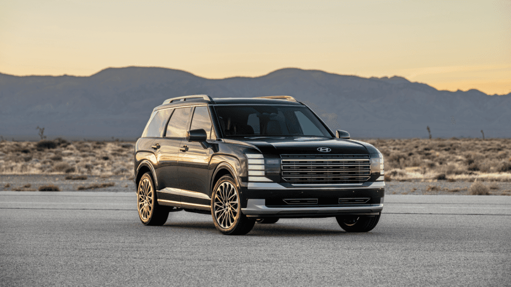 2026 Hyundai Palisade SUV parked on an open road at sunset with bold front grille design.