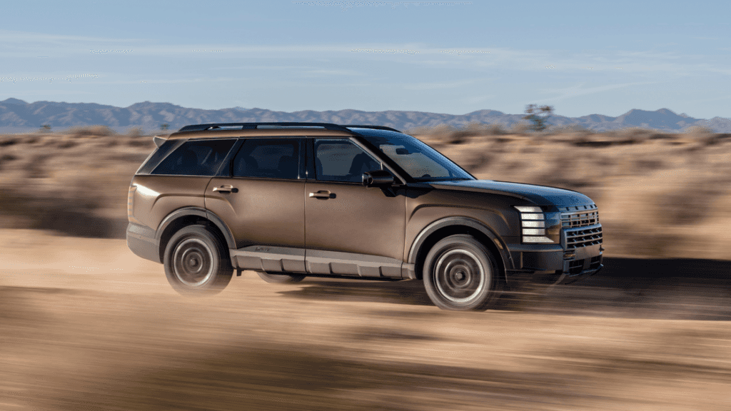 2026 Hyundai Palisade driving off-road in desert terrain with rugged styling and bold side profile.