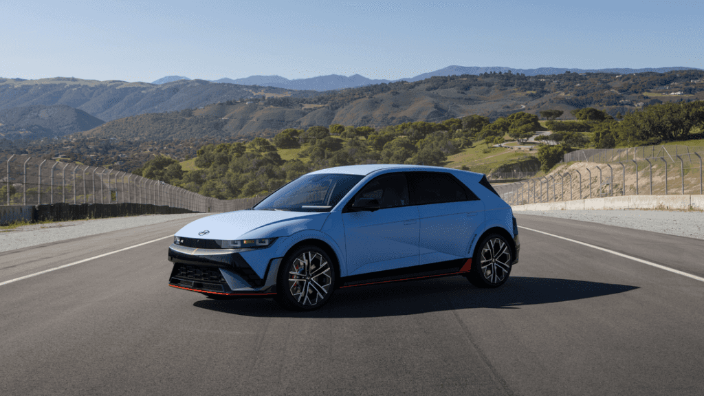2025 Hyundai IONIQ 5 N parked on a racetrack with scenic mountain backdrop and bold exterior design.