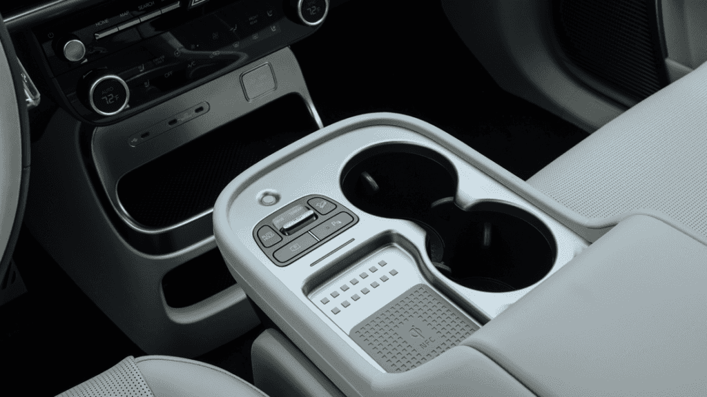 2026 Hyundai IONIQ 9 interior center console with dual cup holders, drive mode buttons, and wireless charger.