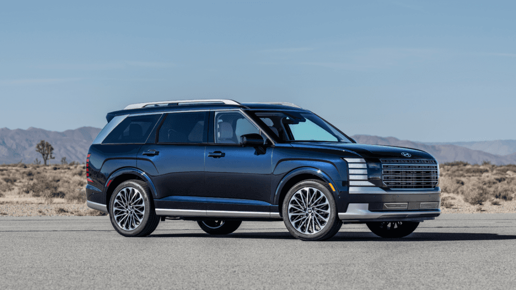 Blue 2026 Hyundai Palisade SUV parked on open road with mountains in background.