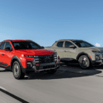 2026 Hyundai Santa Cruz in red and sage green driving side by side on an open highway, emphasizing bold pickup styling with updated grille and LED lighting.