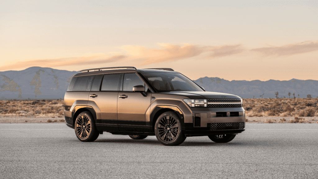 2026 Hyundai Santa Fe Hybrid SUV exterior in bronze finish parked in desert landscape at sunset.