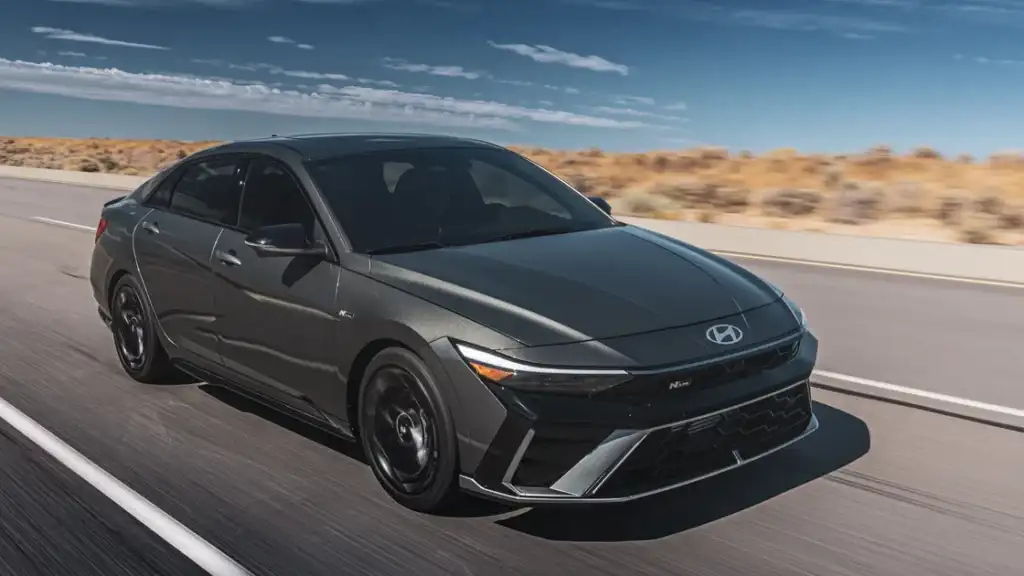 2026 Hyundai Elantra N sports sedan in black driving fast on desert highway with dynamic styling.