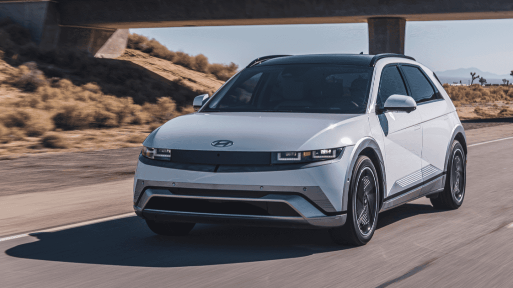 2026 Hyundai IONIQ 5 exterior in white driving on highway under bridge with sleek profile.