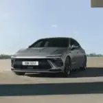 2026 Hyundai Sonata sedan in matte gray parked under modern structure with bold front design.