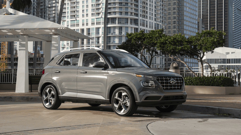 2026 Hyundai Venue exterior in silver parked near modern city buildings with stylish design.