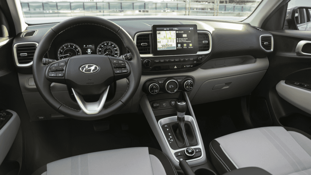 2026 Hyundai Venue interior view with steering wheel, center console, and infotainment screen.