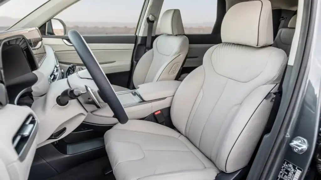 Front interior of the 2025 Hyundai Palisade showcasing beige leather seats and modern dashboard design.