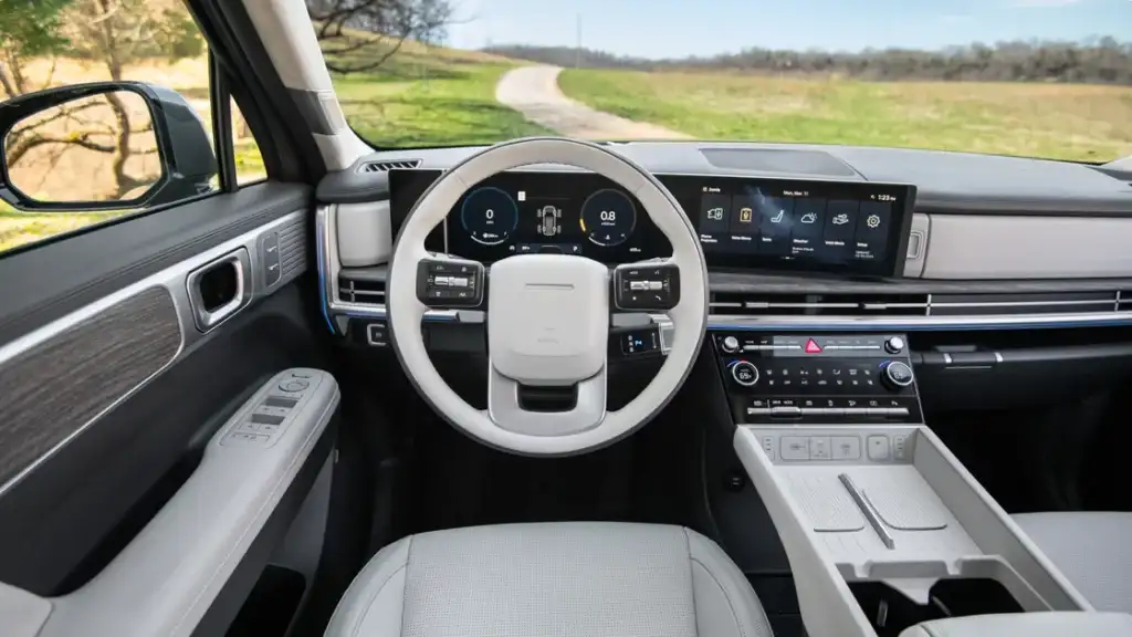Dashboard view of the 2025 Hyundai Santa Fe with digital display, steering controls, and wood trim.