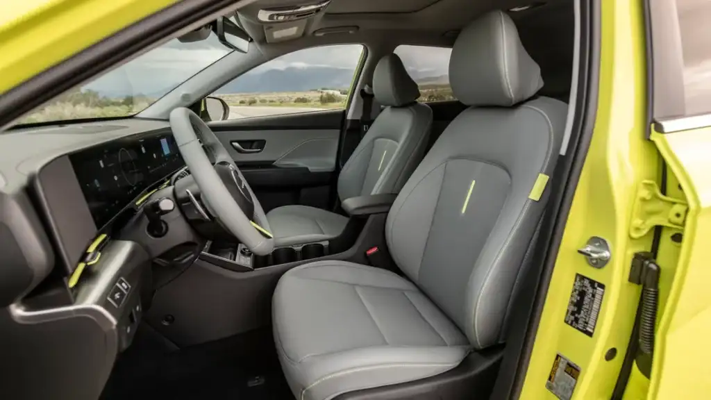 Front seats and steering wheel of 2026 Hyundai Kona Electric with lime accents interior design.
