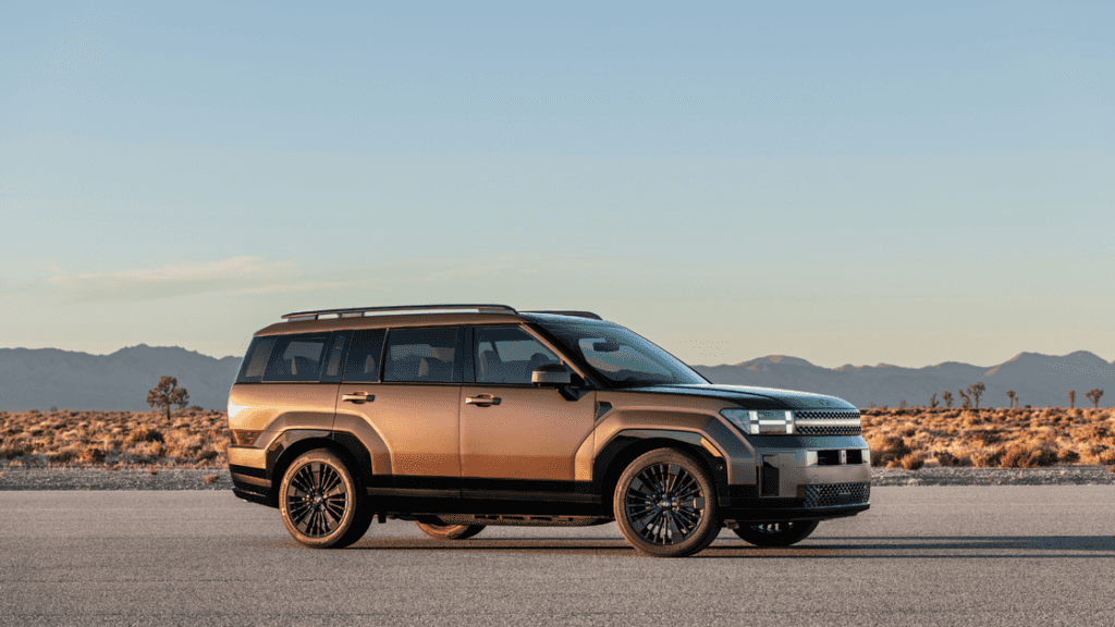2025 Hyundai Santa Fe Hybrid bronze SUV side profile parked in scenic desert landscape.