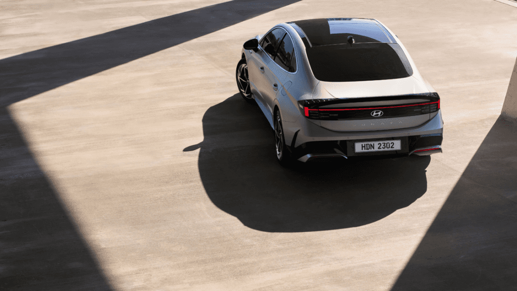 2025 Hyundai Sonata rear view parked under angular shadows showing its sleek modern fastback design.