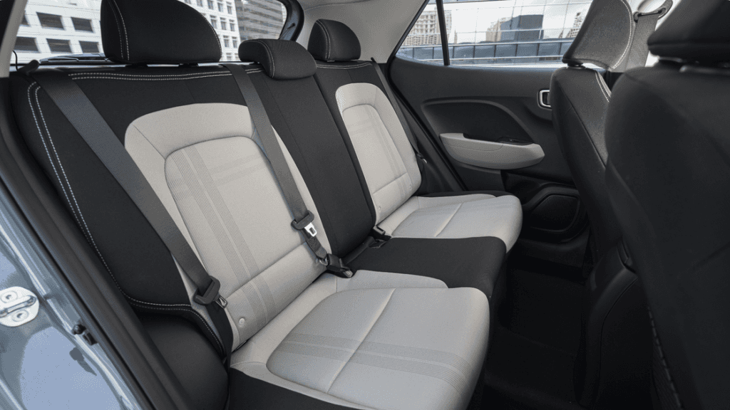 2025 Hyundai Venue rear seats shown in two-tone upholstery with seat belts and cabin details.